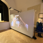 Na výstave premietajú video, ktoré ukazuje postup obliekania kroja | Foto: MIchaela Martišíková, Trnavské rádio