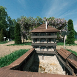 Detail stavby v pozadí s rozkvitnutou vistériou, ktorú v týchto dňoch obletujú včely. | Foto: dv, Trnavské rádio