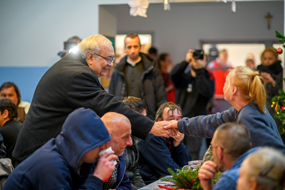 Arcibiskup Ján Orosch si podává ruku s núdznym | Foto: Tomáš Köppl